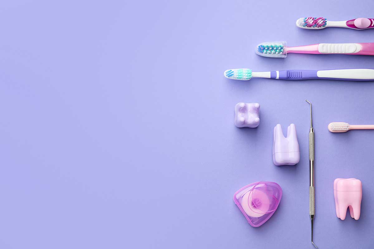 varios cepillos dentales, hilo dental, tubos de pasta dentífrica sobre una mesa.