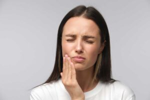 mujer se duele de un flemón dental